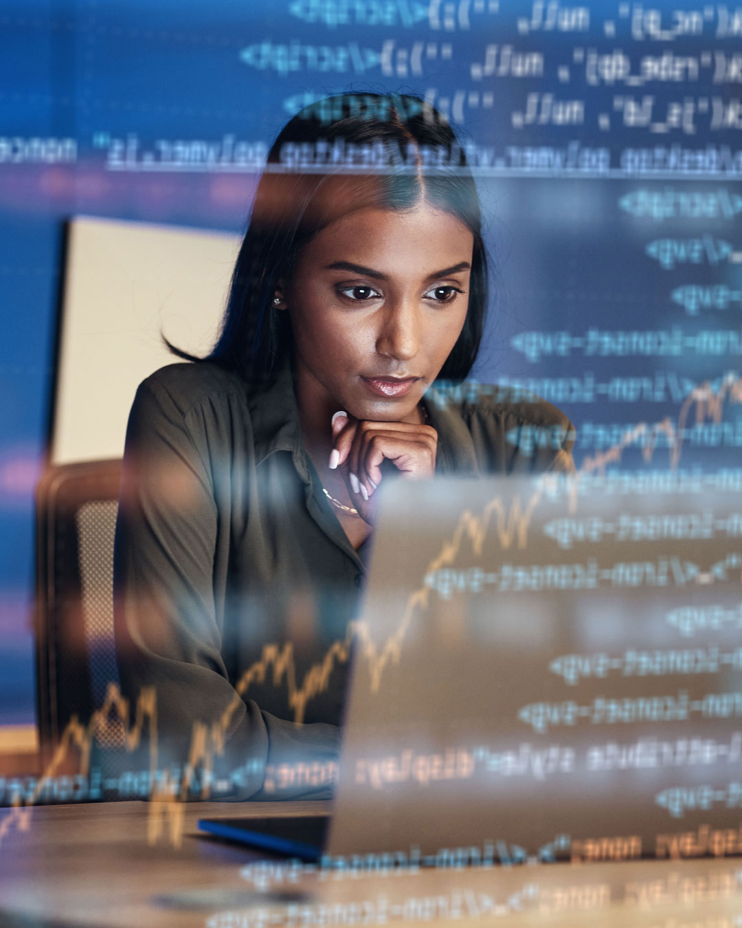 A woman working at a computer with code overlay