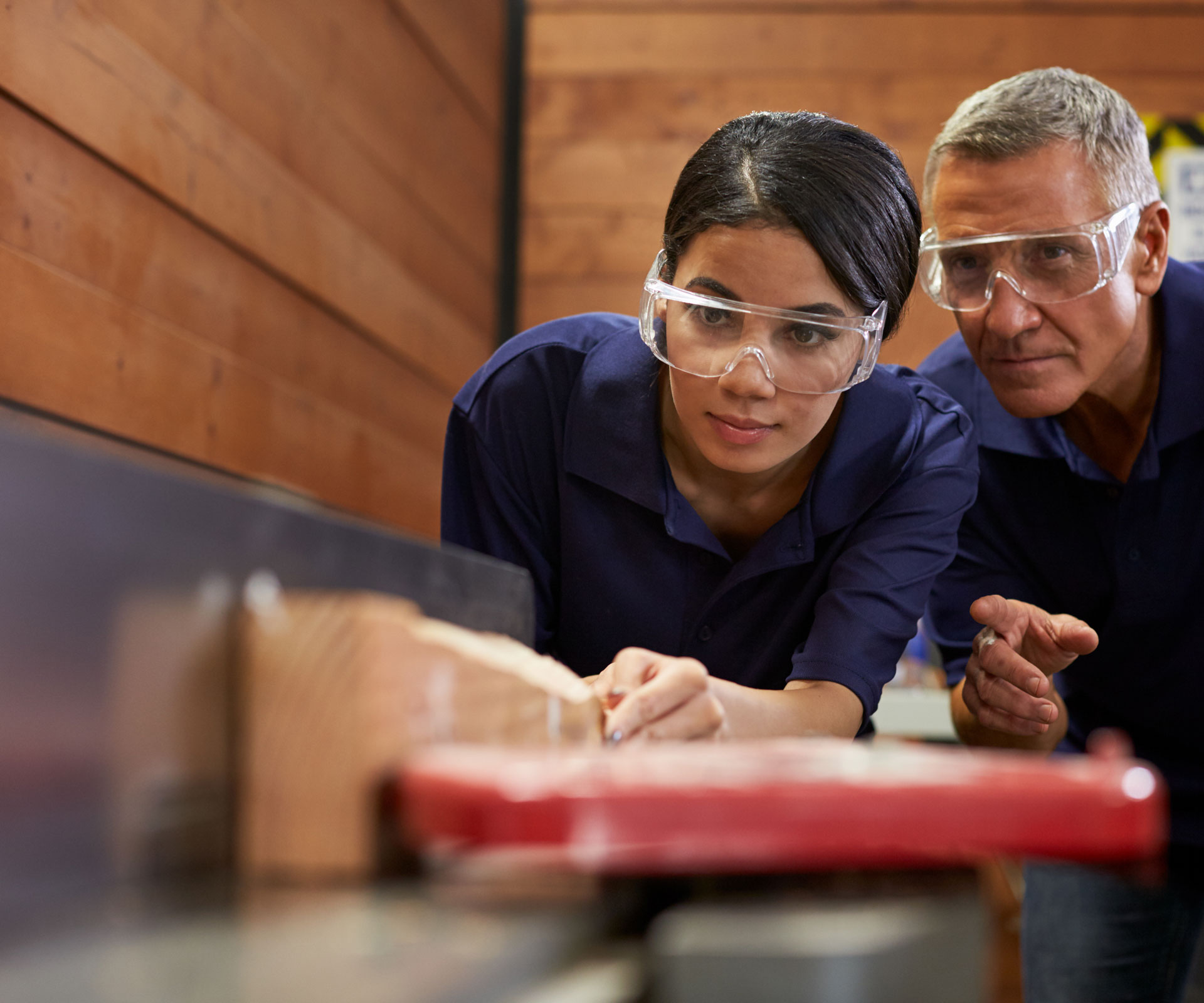 Workers running wood through tablesaw