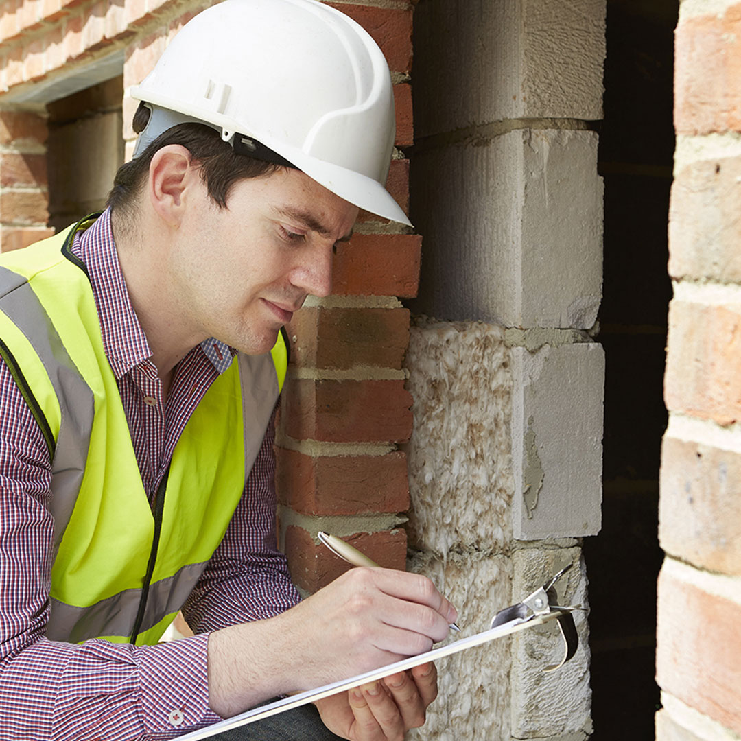 Worker with safety vest inspecting building