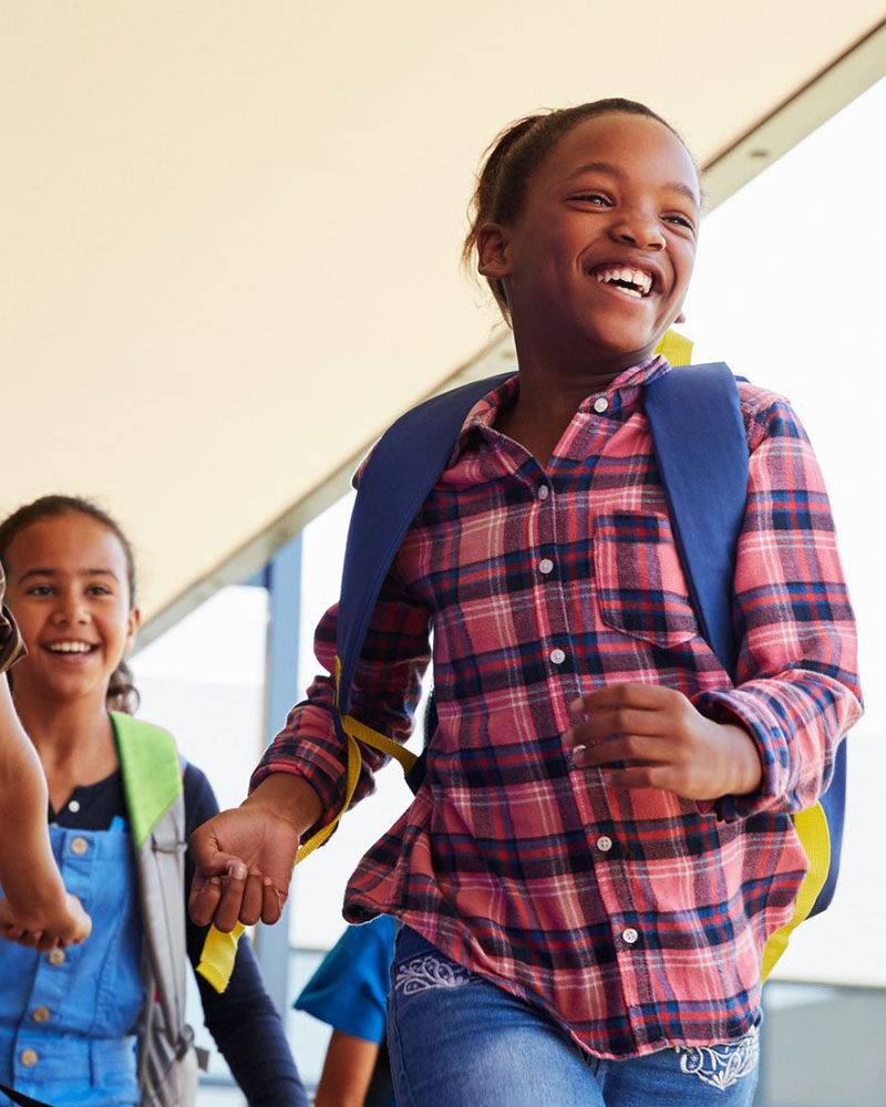 Children smiling in school hallway