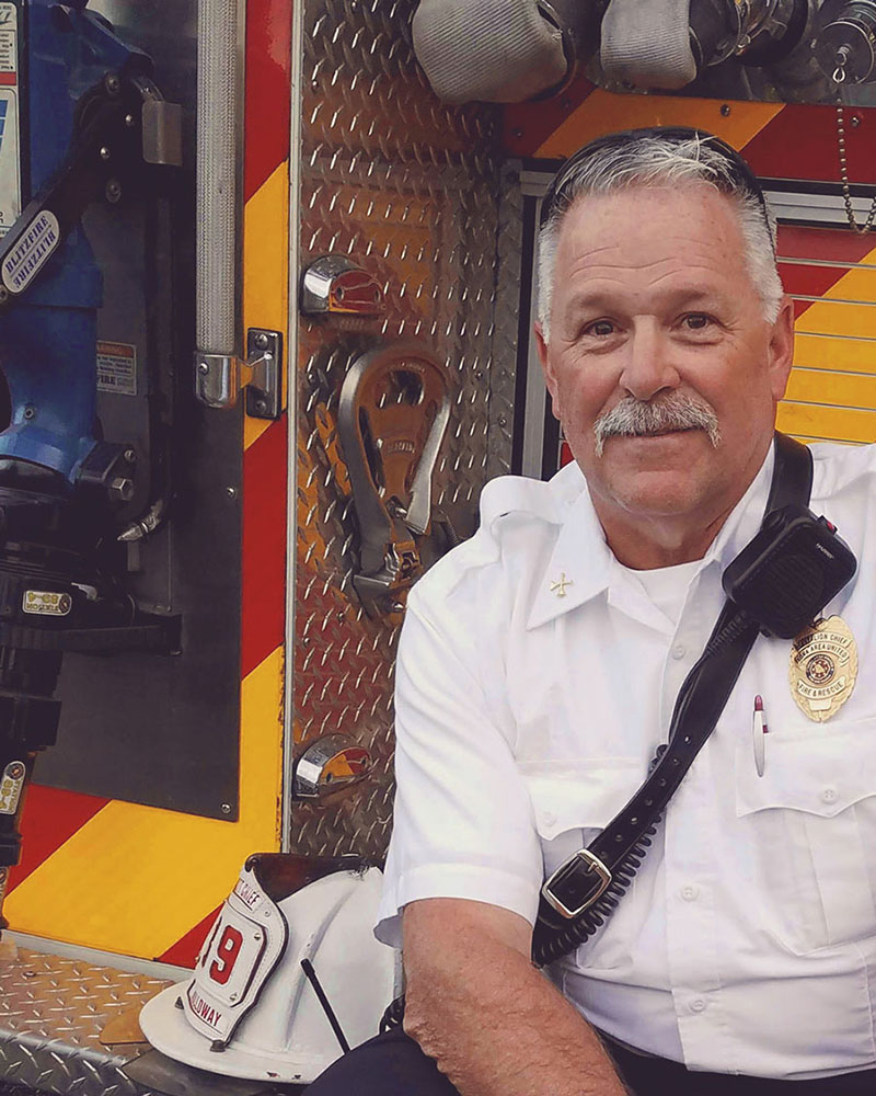 Fire chief on back of fire truck