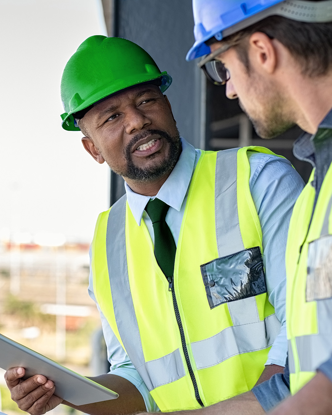 Two men with hard hats at construction site