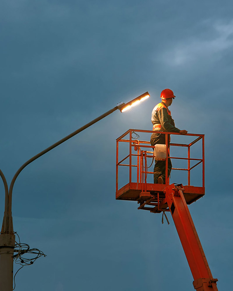 Man on lift fixing outdoor lighting