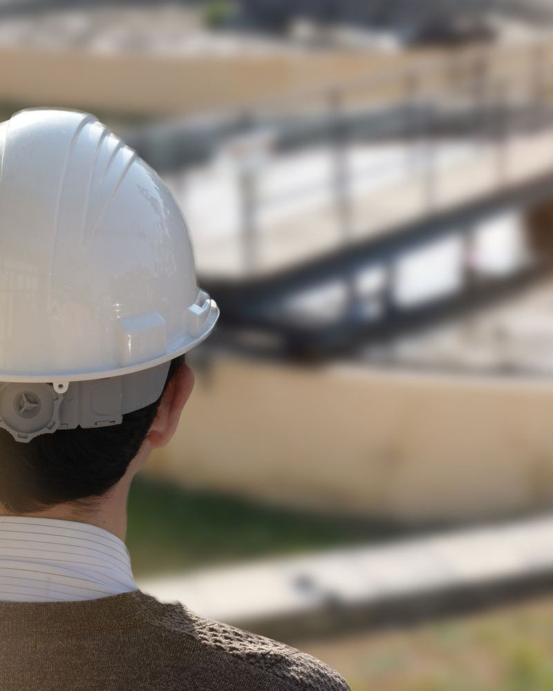 Man with hard hat inspecting water treatment plant
