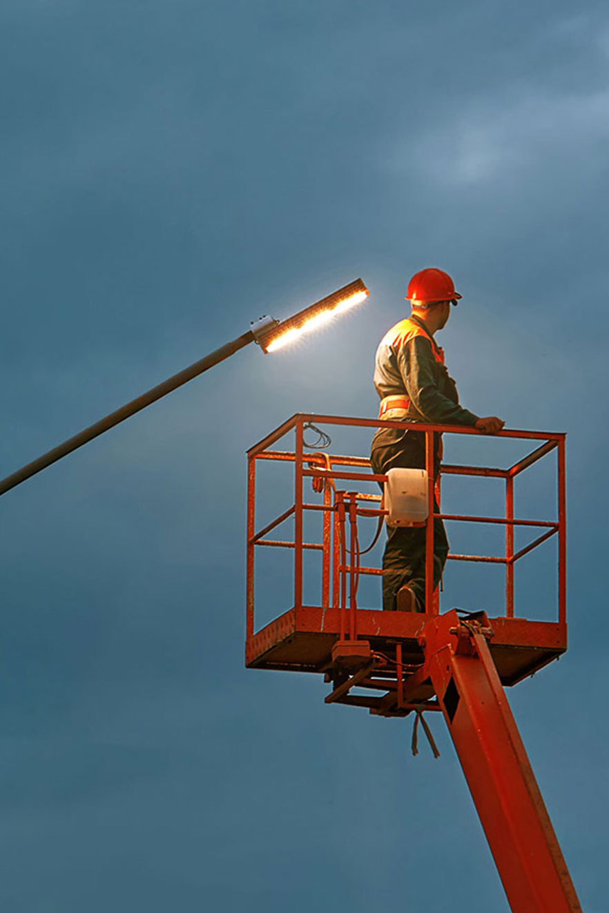 A municipality employee working on electrical lines early in the morning
