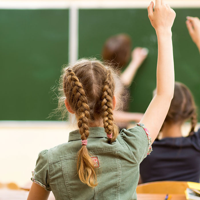 Children raising their hands in a classroom