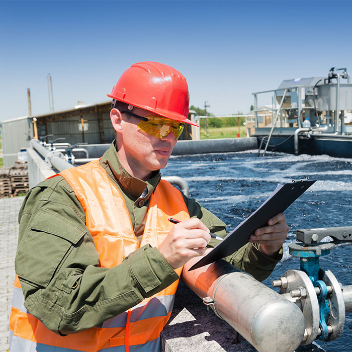 A water treament operator checking a clipboard