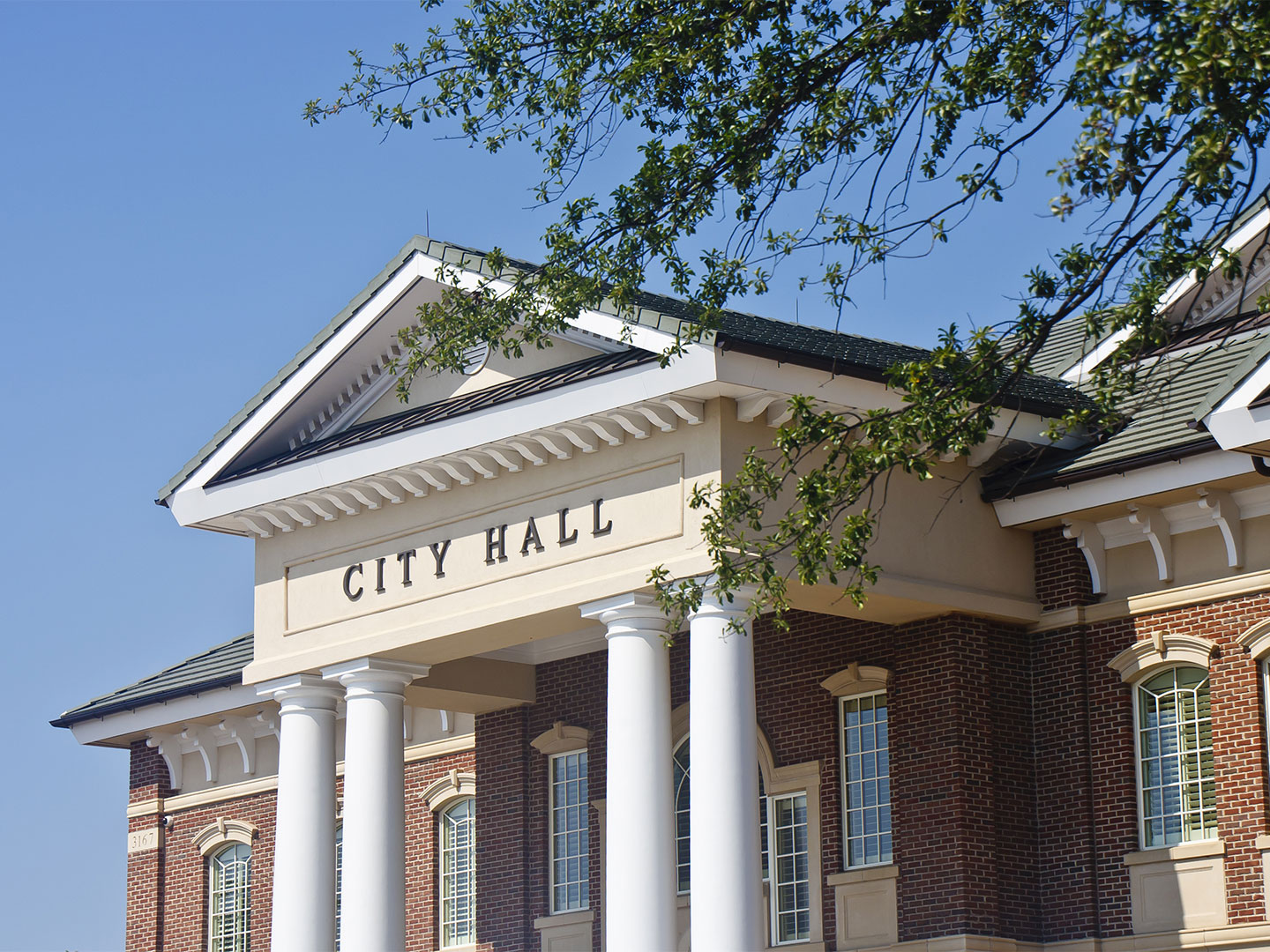 A city hall building framed by a blue sky
