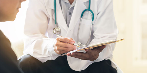 A doctor with a clipboard discussing something important with a patient